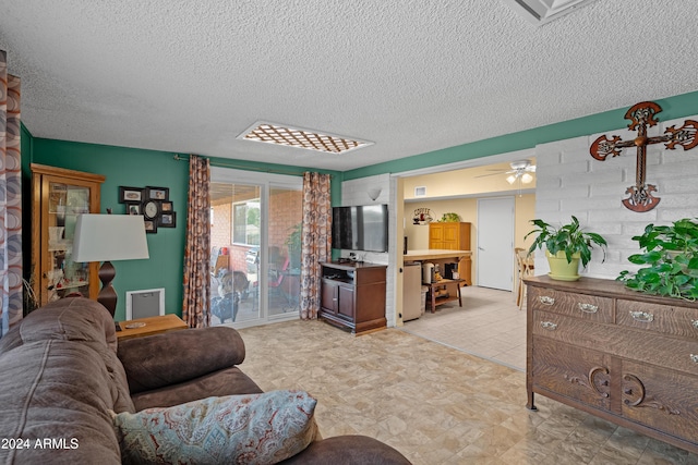 living room with a textured ceiling and ceiling fan