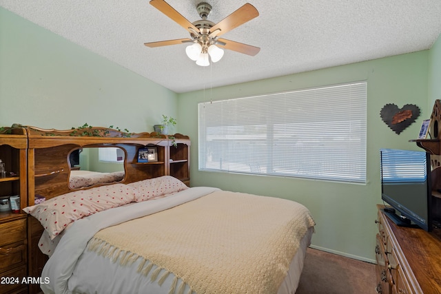 bedroom featuring carpet flooring, ceiling fan, and a textured ceiling