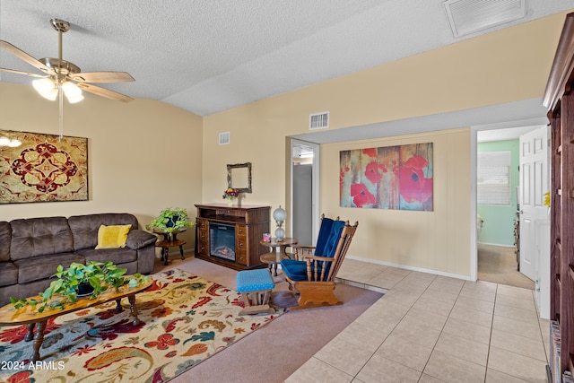 tiled living room with ceiling fan, a textured ceiling, and vaulted ceiling