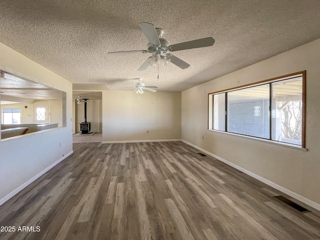 2995 W Rd 1 S, Chino Valley, AZ 86323 - spare room with wood finished floors, a wood stove, a ceiling fan, visible vents, and a textured ceiling