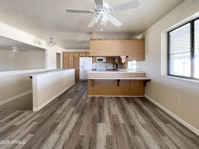 2995 W Rd 1 S, Chino Valley, AZ 86323 - kitchen featuring a peninsula, dark wood-style floors, a textured ceiling, baseboards, and white appliances