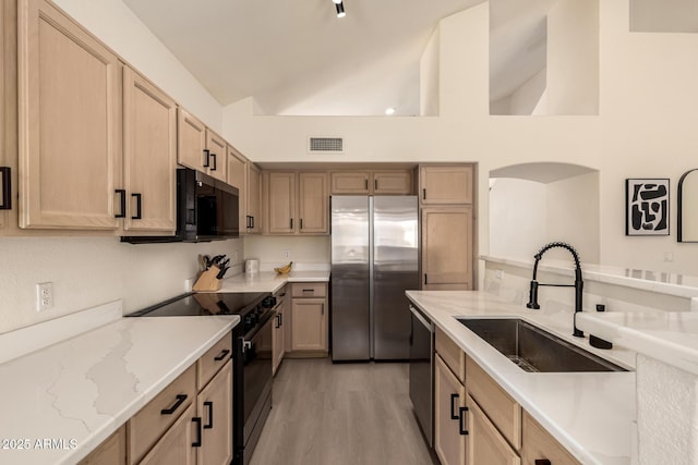 1421 E Charleston Ave, Phoenix, AZ 85022 - kitchen with black appliances, a sink, light wood finished floors, light stone counters, and light brown cabinetry
