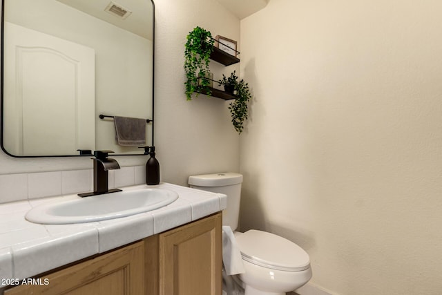1421 E Charleston Ave, Phoenix, AZ 85022 - half bathroom featuring toilet, vanity, and decorative backsplash