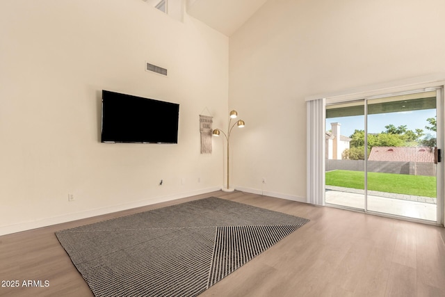 1421 E Charleston Ave, Phoenix, AZ 85022 - unfurnished living room with high vaulted ceiling, wood finished floors, and baseboards
