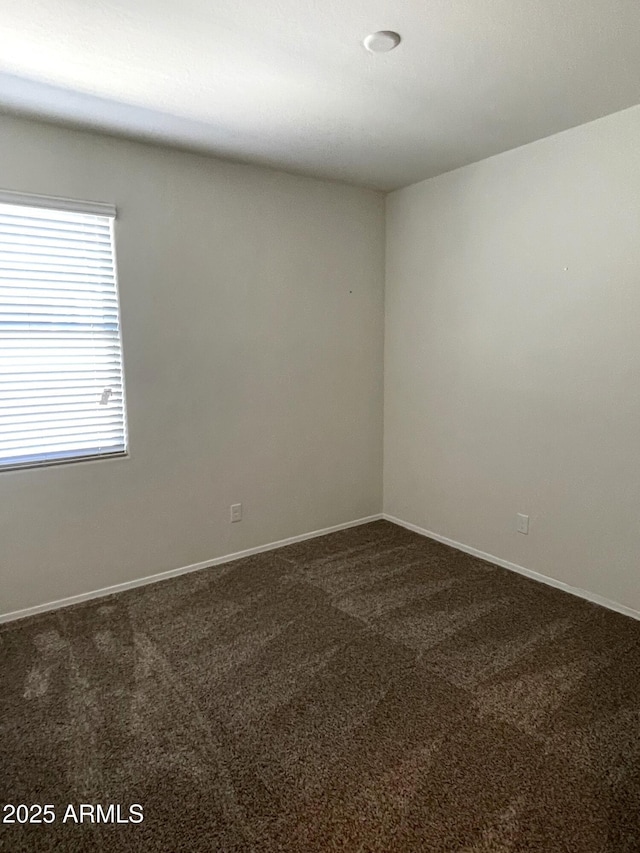 spare room featuring dark carpet