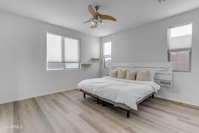 bedroom featuring light hardwood / wood-style flooring, multiple windows, and ceiling fan