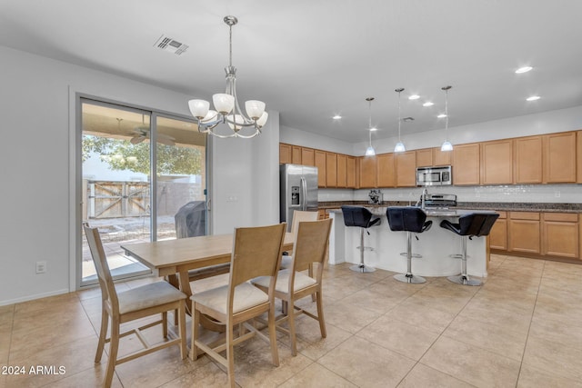 tiled dining room with an inviting chandelier