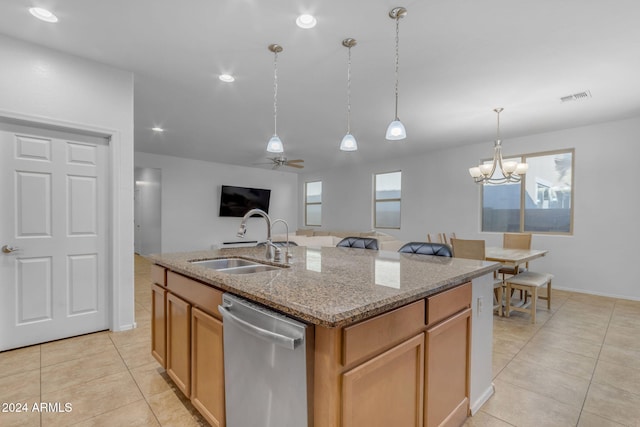 kitchen with sink, hanging light fixtures, light stone counters, stainless steel dishwasher, and a kitchen island with sink