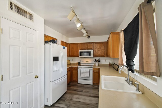 kitchen with dark hardwood / wood-style floors, sink, track lighting, and white appliances