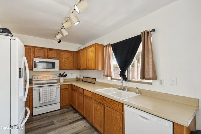 kitchen with sink, track lighting, hardwood / wood-style flooring, and white appliances