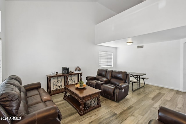 living room with light wood-style floors, baseboards, and visible vents