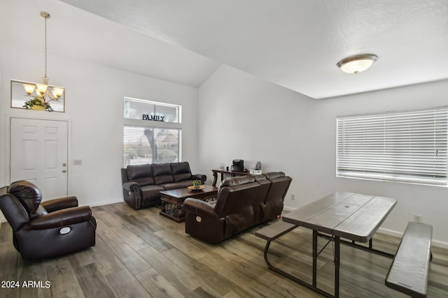 living room with a chandelier, baseboards, wood finished floors, and lofted ceiling