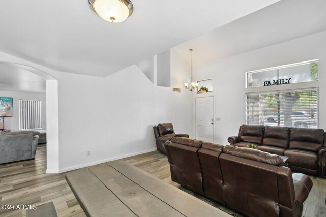 living room with a notable chandelier and light hardwood / wood-style floors