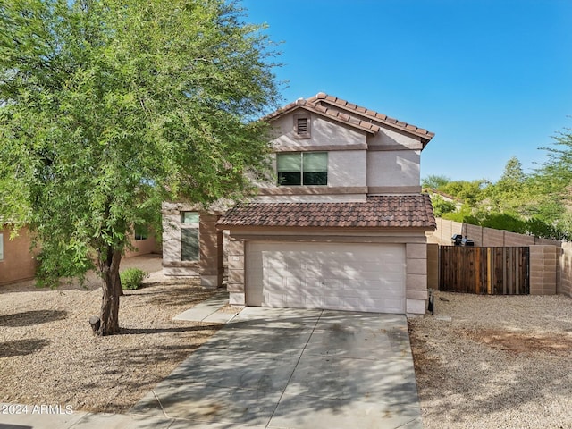 view of front of property with stucco siding, concrete driveway, an attached garage, fence, and a tiled roof