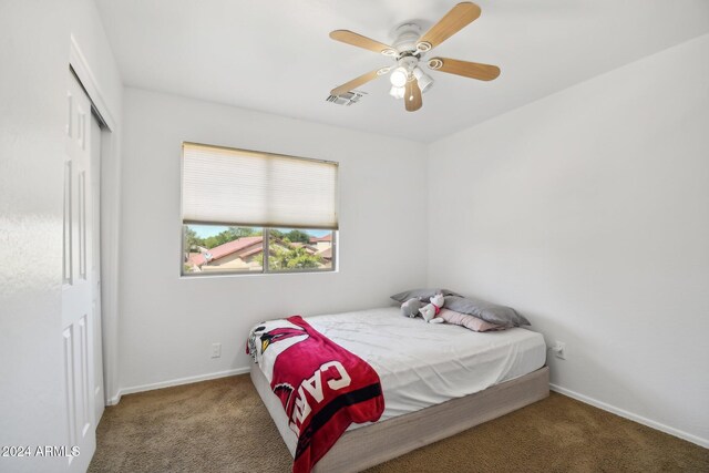 carpeted bedroom with a closet and ceiling fan