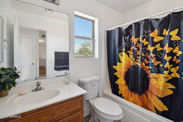 full bathroom with toilet, shower / bathtub combination with curtain, and vanity