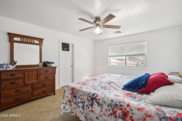 bedroom featuring light carpet, visible vents, and a ceiling fan