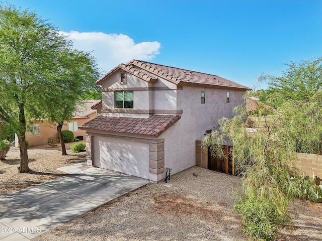 view of front of property with a garage, concrete driveway, a tiled roof, and stucco siding