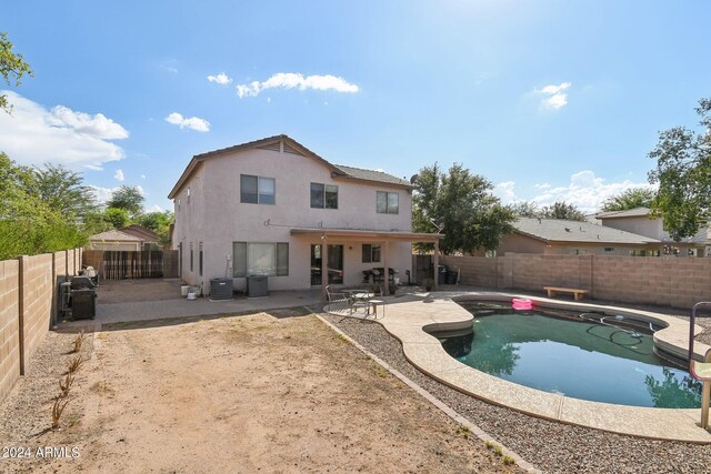 rear view of house with a patio area, central AC, and a fenced in pool