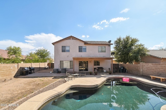 back of house with central AC unit, a fenced in pool, a fenced backyard, a patio area, and stucco siding