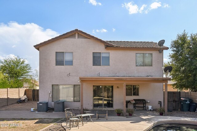 back of property with a patio and central AC