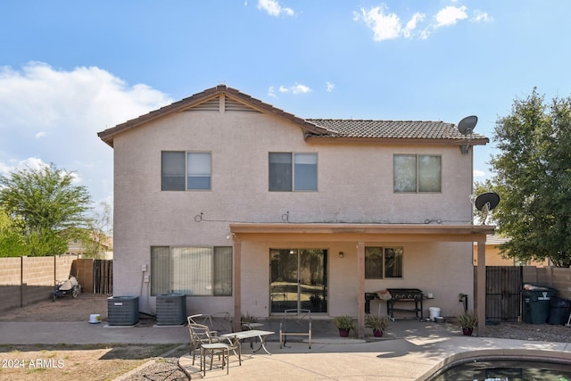 rear view of property with a patio, stucco siding, a gate, central AC, and a fenced backyard