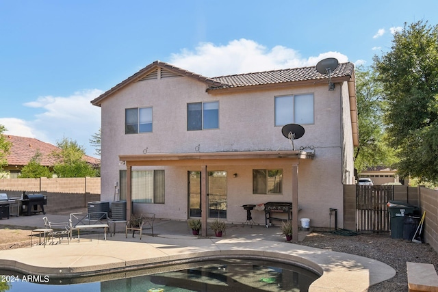 rear view of property with stucco siding, a fenced backyard, and a patio