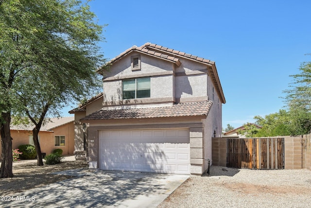 traditional-style home featuring a tile roof, stucco siding, an attached garage, fence, and driveway