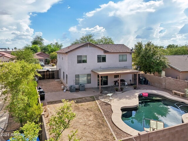 back of house with a fenced in pool, a patio area, and central air condition unit