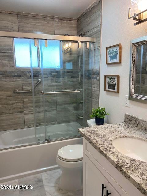 full bathroom featuring combined bath / shower with glass door, vanity, and toilet