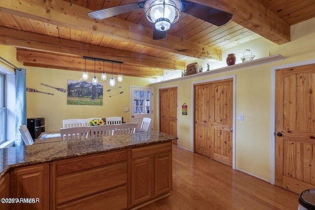4893 W Big Pine Dr, Lakeside, AZ 85929 - kitchen with dark stone countertops, light wood-style flooring, a ceiling fan, beamed ceiling, and wooden ceiling