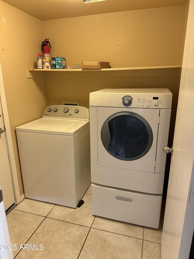 laundry room with washer and dryer and light tile patterned flooring