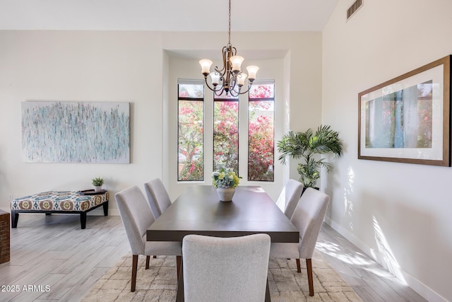 dining space featuring a chandelier and light hardwood / wood-style flooring