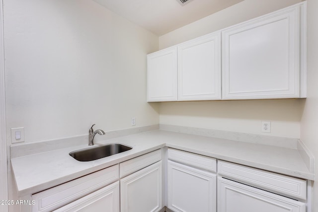 kitchen featuring white cabinetry and sink