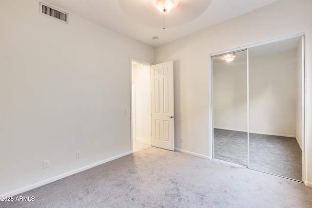 unfurnished bedroom with a closet, ceiling fan, and carpet flooring