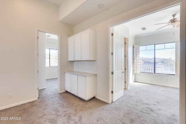 corridor with light carpet and crown molding