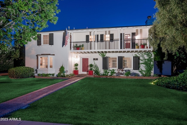 view of front of house featuring a front yard and a balcony