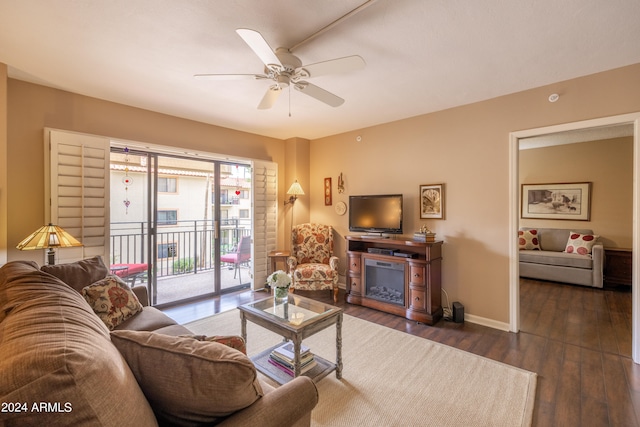 living room featuring a fireplace, dark hardwood / wood-style flooring, and ceiling fan