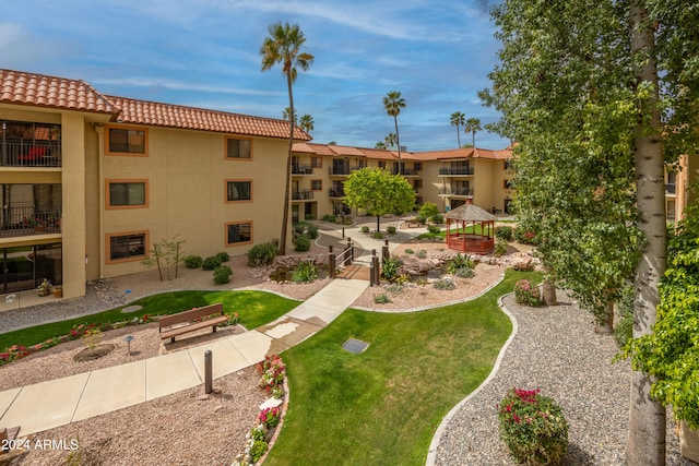 view of property's community with a yard, a gazebo, and a patio area