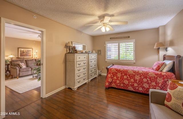 bedroom with ceiling fan, a textured ceiling, and dark hardwood / wood-style flooring