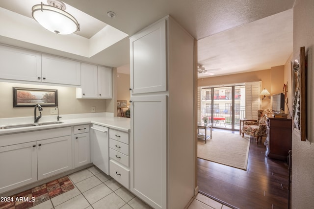 kitchen featuring white cabinets, a textured ceiling, sink, ceiling fan, and light hardwood / wood-style flooring