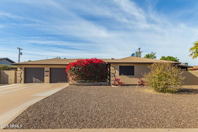 view of front of property featuring central air condition unit and a garage