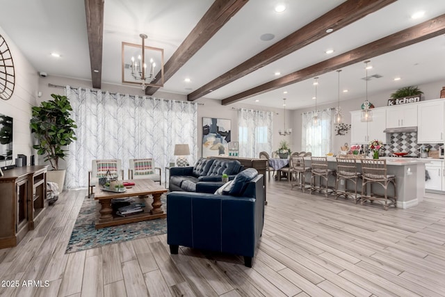 living room with an inviting chandelier, recessed lighting, visible vents, beamed ceiling, and light wood finished floors