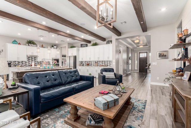 living area featuring recessed lighting, a notable chandelier, visible vents, and beam ceiling