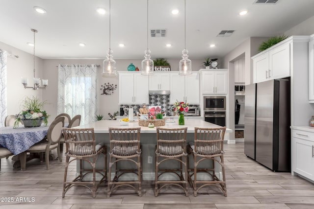 kitchen featuring white cabinets, light countertops, visible vents, and stainless steel appliances