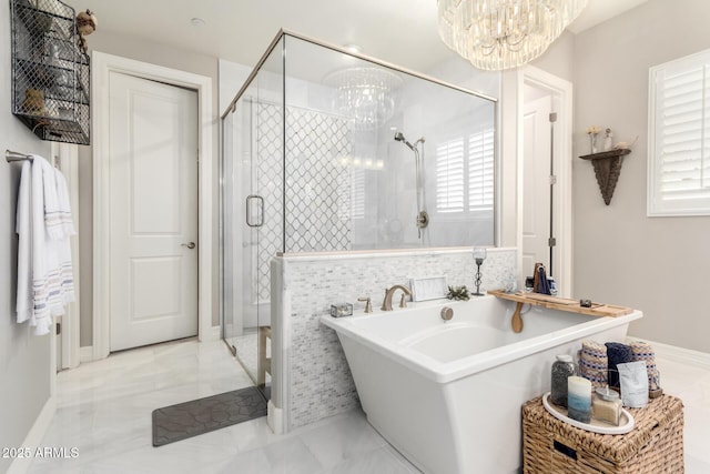full bath with a chandelier, a freestanding bath, a stall shower, and a healthy amount of sunlight