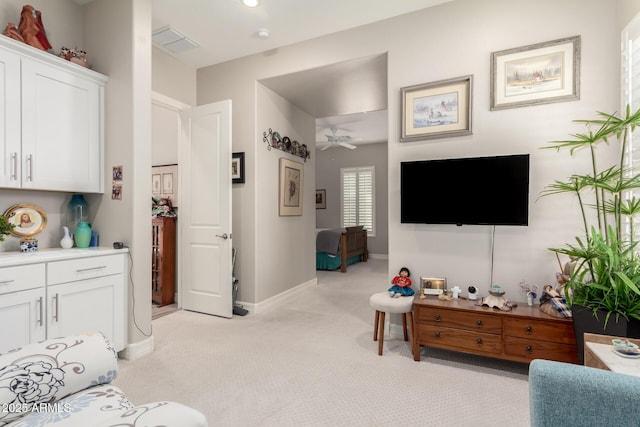living room with visible vents, light colored carpet, baseboards, and ceiling fan