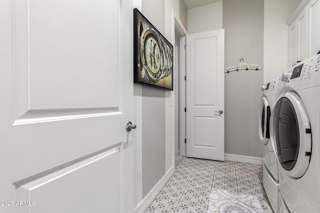 clothes washing area with cabinet space, washer and clothes dryer, and baseboards