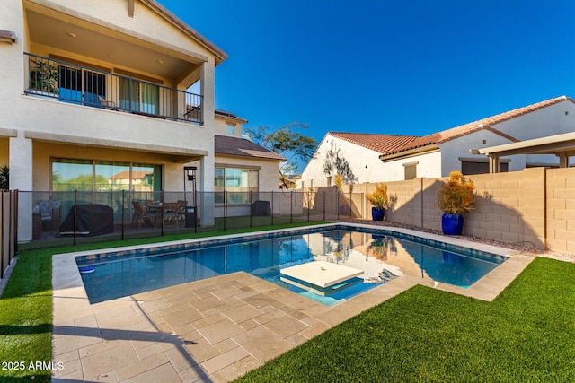 view of pool with a patio area, a fenced backyard, and a lawn