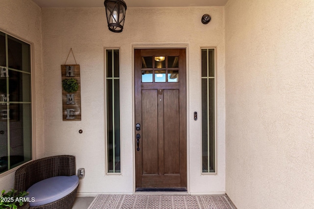 entrance to property featuring stucco siding
